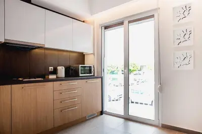 a kitchen with wooden cabinets and a large window at TONI'S Spacious Apartment next to Acropolis Museum in Athens