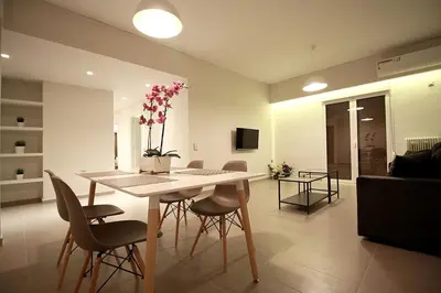a living room with a dining room table with chairs at TONI'S Spacious Apartment next to Acropolis Museum in Athens