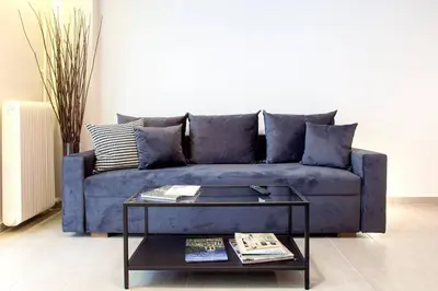 a blue couch in a living room with a coffee table at TONI'S Spacious Apartment next to Acropolis Museum in Athens