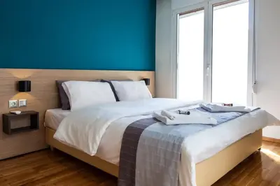 a bedroom with a large bed with a blue wall at TONI'S Spacious Apartment next to Acropolis Museum in Athens