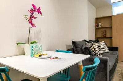 a living room with a white table and blue chairs at TONI'S Studio Syntagma, 1 min from Metro station in Athens