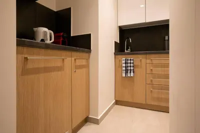 a kitchen with wooden cabinets and a counter top at TONI'S Studio Syntagma, 1 min from Metro station in Athens