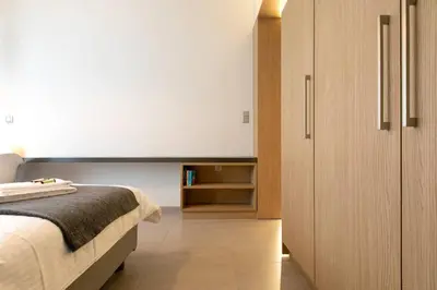 a bedroom with a bed and a wooden cabinet at TONI'S Studio Syntagma, 1 min from Metro station in Athens