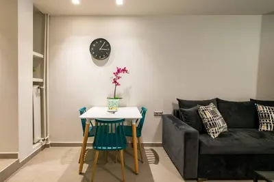 a living room with a couch and a table and a clock at TONI'S Studio Syntagma, 1 min from Metro station in Athens