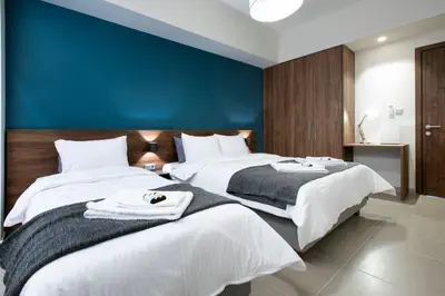 two beds in a bedroom with a blue wall at TONI'S Local retreat for Magicians in Koukaki in Athens