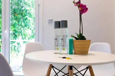 a white table with a vase and flowers on it at TONI'S Local retreat for Magicians in Koukaki in Athens