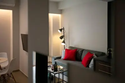 a living room with a gray couch with red pillows at TONI'S Local retreat for Magicians in Koukaki in Athens