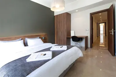 a bedroom with a large bed with two towels on it at TONI'S Grande Home next to A.Museum in Athens