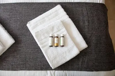 three bottles of essential oils sitting on top of a bed at TONI'S Grande Home next to A.Museum in Athens