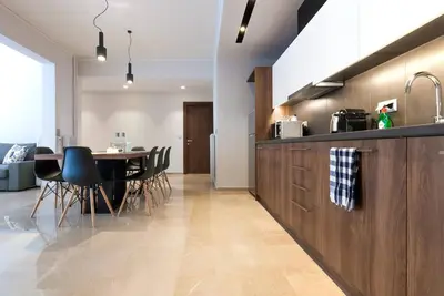 a kitchen and dining room with a table and chairs at TONI'S Grande Home next to A.Museum in Athens