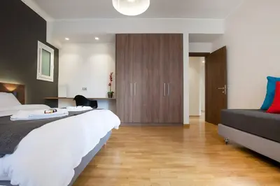a bedroom with a large bed and a wooden floor at TONI'S Grande Home next to A.Museum in Athens