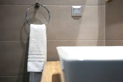 a bathroom with a white towel hanging on a wall at TONI'S Grande Home next to A.Museum in Athens