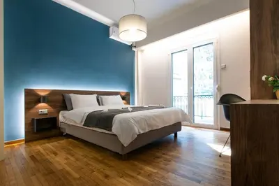 a bedroom with a large bed with a blue wall at TONI'S 2BD Stay in Charming Historical centre in Athens