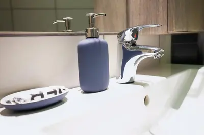 a blue soap bottle sitting on a bathroom sink at TONI'S 2BD Modern flat in Koukaki near Acropoli in Athens