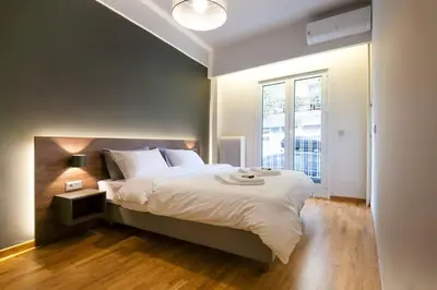 a bedroom with a large bed and a window at TONI'S 2BD Modern flat in Koukaki near Acropoli in Athens
