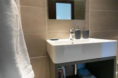 a bathroom with a white sink and a mirror at TONI'S 2BD Home for Superman and Superwoman. in Athens
