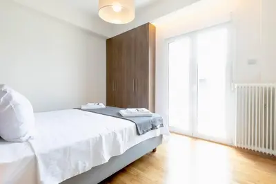 a bedroom with a white bed and a large window at TONI'S 2BD Home for Superman and Superwoman. in Athens