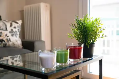 a glass table with four different colored candles on it at TONI'S 2BD Home for Superman and Superwoman. in Athens