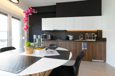 a kitchen with a white table and black cabinets at TONI'S 2BD Home for Superman and Superwoman. in Athens