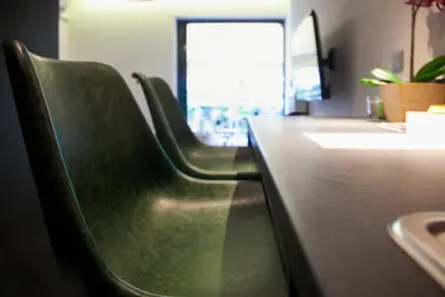 two green leather chairs sitting at a counter in an office at TONI'S STUDIO for couples near ACROPOLIS Museum in Athens
