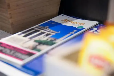 a stack of magazines sitting on top of a table at TONI'S STUDIO for couples near ACROPOLIS Museum in Athens