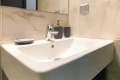 a white sink with a faucet in a bathroom at TONI'S STUDIO for couples near ACROPOLIS Museum in Athens