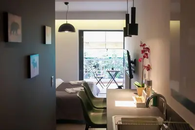 a kitchen and living room with a bed and a window at TONI'S STUDIO for couples near ACROPOLIS Museum in Athens