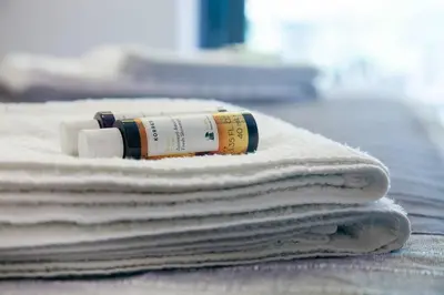 a stack of towels on a table with a bottle of shampoo at TONI'S STUDIO for couples near ACROPOLIS Museum in Athens