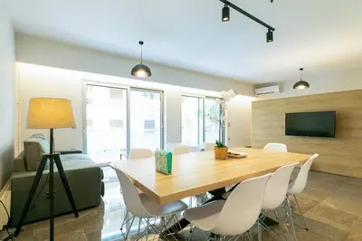 a dining room with a wooden table and white chairs at TONI'S makes you an offer, you cannot refuse. in Athens