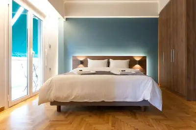 a bedroom with a large bed with a blue wall at TONI'S 3BD Amazing Home for Wizards and families! in Athens