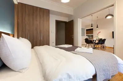 a bedroom with a bed with white pillows and a table at TONI'S 3BD Amazing Home for Wizards and families! in Athens