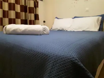 a white towel laying on top of a bed at Vasi in Markopoulo