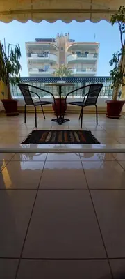 a table and chairs in a room with a building at Vasi in Markopoulo