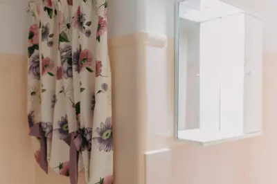 a shower curtain with flowers on it next to a window at BEST HOUSE, Attiki Metro, Athens in Athens