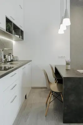 a kitchen with white cabinets and a table and chairs at Nest Apartment in Athens