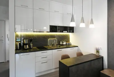 a kitchen with white cabinets and a black counter top at Nest Apartment in Athens