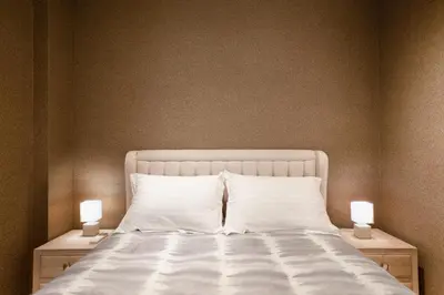 a bed with white sheets and two lamps on night stands at Near Acropolis brand new 1 min from metro in Athens