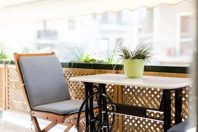 a table and chair on a balcony with a potted plant at Near Acropolis brand new 1 min from metro in Athens