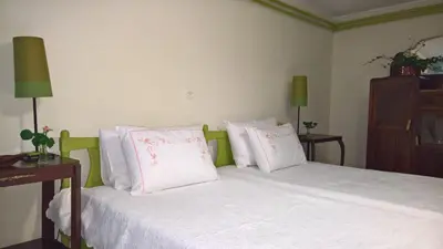 a bedroom with a bed with white sheets and pink pillows at Spitaki Spata Airport Studio in Spáta