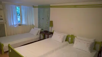 a bedroom with two beds and a window at Spitaki Spata Airport Studio in Spáta