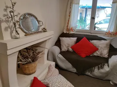 a room with a couch with pillows and a mirror at Spitaki Spata Airport Studio in Spáta