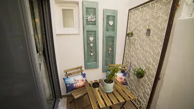 a balcony with a table and two potted plants at D16-Cosy downtown apartment in Athens