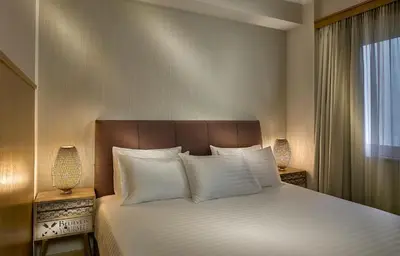 a bedroom with a bed with white pillows and a window at Acropolis View Penthouse in Athens