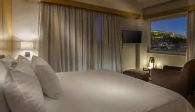 a hotel room with a bed and a window at Acropolis View Penthouse in Athens