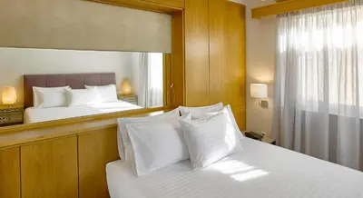 a bedroom with a mirror and a bed with white pillows at Acropolis View Penthouse in Athens