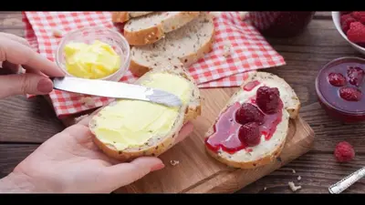 a person cutting a piece of bread with butter and berries at Acropolis brand new 1min from metro! in Athens