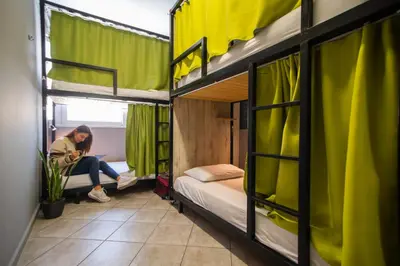 a woman sitting on a bed in a room with two bunk beds at Bedway Athens Hostel in Athens