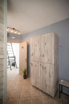 a large wooden cabinet in a room with a staircase at Bedway Athens Hostel in Athens
