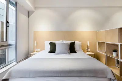 a bedroom with a large white bed and a window at Ermou str. Elegant Apartments by UPSTREET in Athens