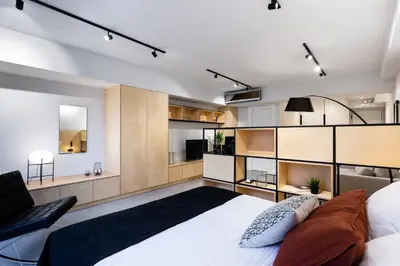 a bedroom with a large white bed and a chair at Ermou str. Elegant Apartments by UPSTREET in Athens